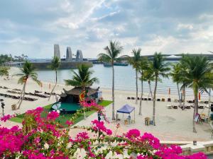 - une plage avec des palmiers et une étendue d'eau dans l'établissement Le Ciel Phu Quoc - Hillside Apartment, à Duong Dong