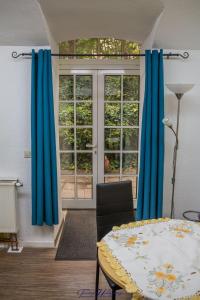 ドレスデンにあるFerienwohnung-Franziska-Wuensche-Wohnung-1の青いカーテン、テーブル、窓が備わる客室です。