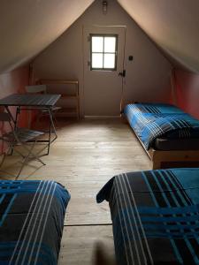 Habitación en el ático con 2 camas y mesa en Camp du Père Castor en Simard