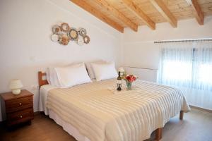 a bedroom with a bed with a table with flowers on it at Nana's Guesthouse in Samos