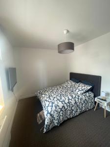 a bedroom with a bed with a blue and white comforter at Séjourner chez Mina in Lille