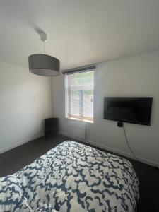 a bedroom with a bed and a flat screen tv at Séjourner chez Mina in Lille