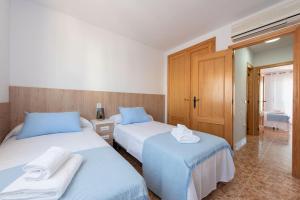 due letti in una stanza d'albergo con asciugamani sopra di Sunny Home Gran Alacant a Gran Alacant Altre 30 foto