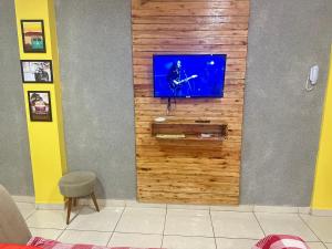 TV en una pared de madera en una habitación en AP+preço popular+ar condicionado+internet 300mb, en Goiânia