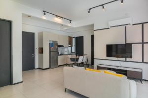 a living room with a couch and a kitchen at Urban Suite By Bold@Seaview in Jelutong