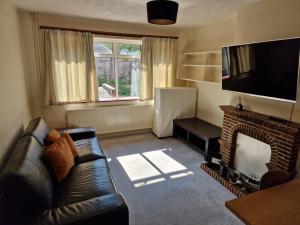 sala de estar con sofá y chimenea en Millmead Apartment in central Guildford with parking, en Guildford