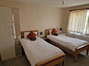 Duas camas num quarto com uma janela em Millmead Apartment in central Guildford with parking em Guildford