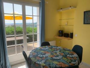 a dining room with a table and a large window at Maison vue mer baie de Saint Brieuc in Plérin