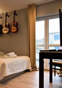1 dormitorio con 1 cama y guitarras en la pared en Kamienica Poznańska 7, en Bydgoszcz