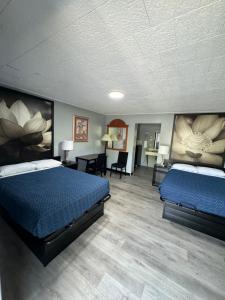 ein Hotelzimmer mit 2 Betten und einem Schreibtisch in der Unterkunft Acorn Motel in Black Mountain