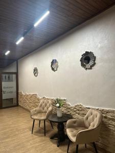 Pokój z 2 krzesłami, stołem i ścianą w obiekcie Hotel Soimul w mieście Poiana Brașov