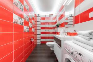 a red and white bathroom with a toilet and a sink at Apartament Mierzeja Park z 1 sypialnią in Sztutowo