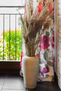 a vase with dried grass in a window at Apartament Mierzeja Park z 1 sypialnią in Sztutowo +6 photos