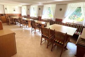 a dining room with tables and chairs and windows at Haus PANORAMA - Appartement Auszeit 5 in Braunlage +6 photos