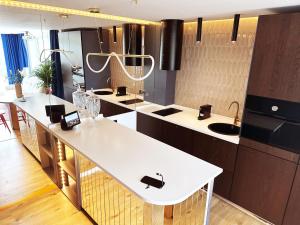 uma cozinha com balcões brancos e uma mesa branca em Ambient lounge with sundeck and free parking em Bratislava