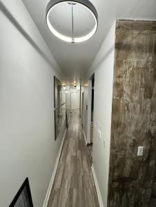 an empty hallway with a large ceiling light and a long corridor at 3 bedroom Condo in Central Park/ Times Square/ Hudson Yards in New York +1 photo