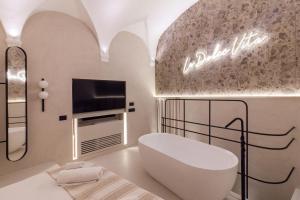 um quarto com uma cama, uma televisão e uma banheira em Pànto - Rooftop boutique rooms em Palermo