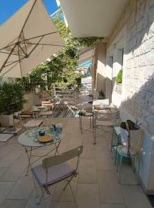 a patio with tables and chairs and an umbrella at B&B 125Metri sul mare in Sirolo