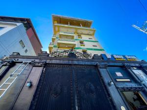 a tall yellow building with a black door at Chanel Paris Hotel powered by Cocotel in Manila