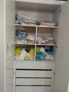 ein Schrank mit vielen verschiedenen farbigen Handtüchern in der Unterkunft CASA 2024 - São João Campina Grande/PB in Campina Grande