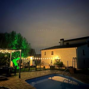 un patio trasero con piscina por la noche en CAN SIMON en San Dalmay