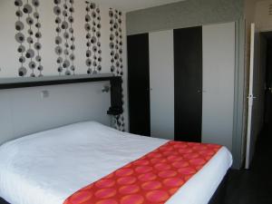 a bedroom with a white bed with a red blanket at Hôtel Le Nautic in Arcachon