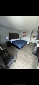 a bedroom with a blue bed and a desk and a chair at Acorn Motel in Black Mountain