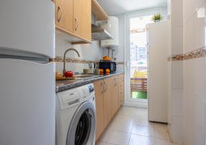 a kitchen with a washing machine and a window at Torremolinos Centro terraza wifi parking ascensor a la playa a 5 min in Torremolinos