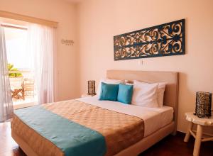 - une chambre avec un lit doté d'oreillers bleus et blancs dans l'établissement Summer House Collection - A Secluded Getaway, à Perissa