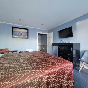 um quarto de hotel com uma cama e uma televisão de ecrã plano em Guest Harbor Inn- Port Of Los Angeles San Pedro em San Pedro