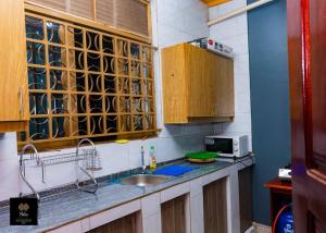 a kitchen with a sink and a microwave at Nile Homestay in Jinja