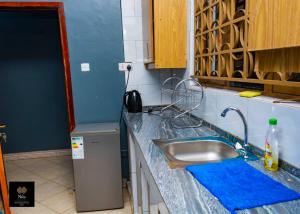 a kitchen with a sink and a blue counter top at Nile Homestay in Jinja