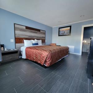 Schlafzimmer mit einem großen Bett mit einem Kopfteil aus Holz in der Unterkunft Guest Harbor Inn- Port Of Los Angeles San Pedro in San Pedro