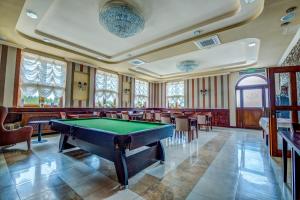 a pool table in a room with tables and chairs at Hotel Regent in Pawłów