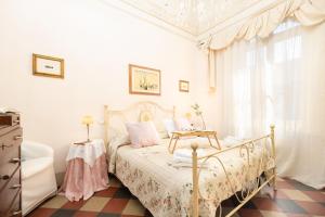 a white bedroom with a bed and a table at Villa Lola - Liberty Dreamscape in Viareggio