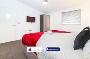 1 dormitorio con 1 cama grande con manta roja en Stylish 2 Bedroom Apartment By Your Lettings Short Lets & Serviced Accommodation Peterborough With Free WiFi,Parking And More en Huntingdon
