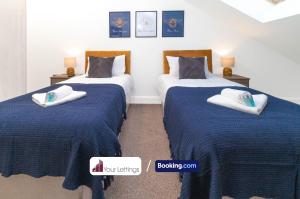 2 camas en una habitación con sábanas azules y blancas en Stylish 2 Bedroom Apartment By Your Lettings Short Lets & Serviced Accommodation Peterborough With Free WiFi,Parking And More en Huntingdon