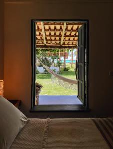 1 dormitorio con ventana con vistas a un patio en Pousada Quintal Caraíva, en Caraíva