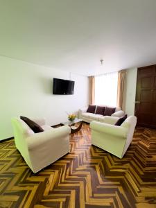 ein Wohnzimmer mit 2 Sofas und einem TV in der Unterkunft Casa Vallecito in Arequipa