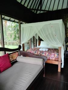sypialnia z łóżkiem z baldachimem w obiekcie BINTANG MUNDUK w mieście Munduk