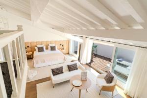 サントロペにあるVillas by Le Yaca Saint-Tropezのベッドルーム1室(ベッド1台付)、リビングルームが備わります。