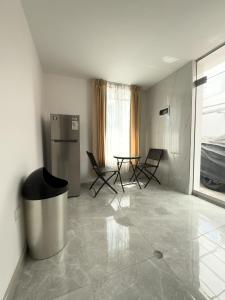 アレキパにあるCasa Vallecitoの冷蔵庫、テーブル、椅子が備わる客室です。