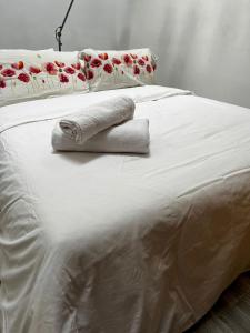 uma cama branca com duas toalhas dobráveis em Penthouse, 3Bed in Heart of Malasana em Madri