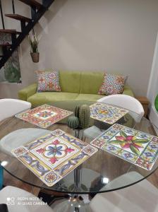 sala de estar con mesa de cristal con sillas y sofá en Suite per famiglie"Civico 65", en Palagianello