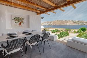 een eetkamer met een tafel en stoelen en uitzicht op de oceaan bij Healthy House Mykonos in Ornos