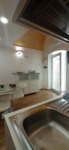 eine Küche mit einem Waschbecken und einem Tisch in einem Zimmer in der Unterkunft Suite per famiglie"Civico 65" in Palagianello