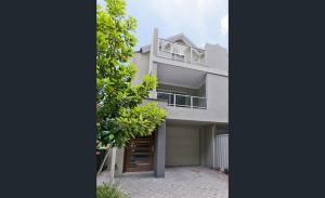 a white house with a tree in front of it at Urban Retreat CBD Perth House 4BR 3BA 2PK SLEEP 8! in Perth