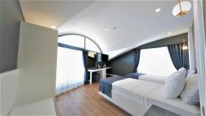 a bedroom with a white bed and two windows at Mai İnci Otel in Antalya +37 photos