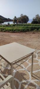 uma mesa de piquenique branca sentada num chão de pedra em White Lotus seaside apartment em Kinion