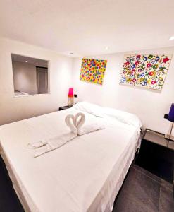 a bedroom with a white bed with two hearts on it at Old Town Portofino Coast in Rapallo